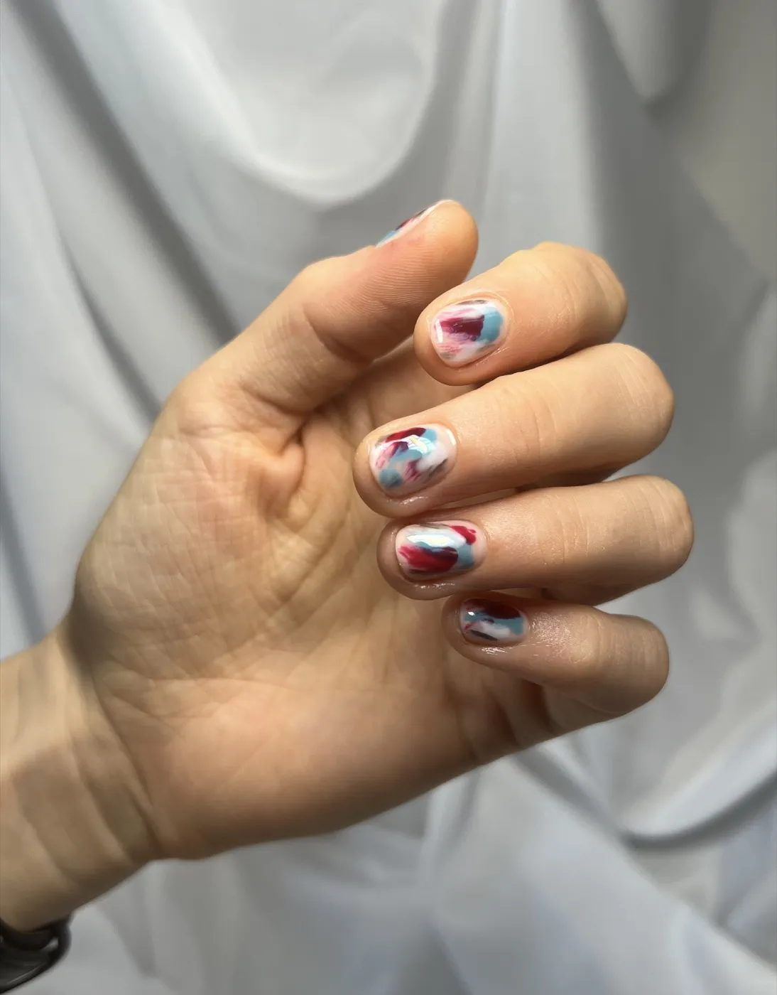 Nail art s abstraktními tahy v bílé, vínové a modré